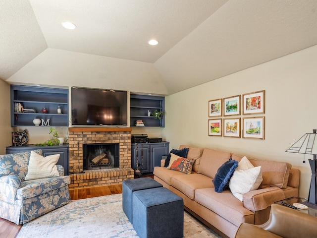 living room with recessed lighting, wood finished floors, a fireplace, and vaulted ceiling