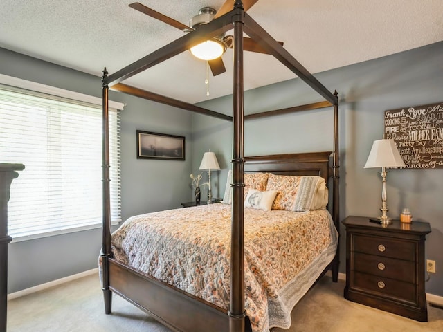 carpeted bedroom with a ceiling fan, baseboards, and a textured ceiling