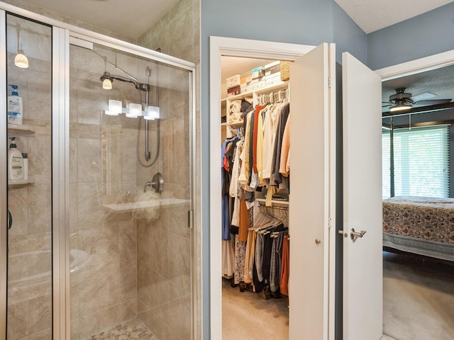 bathroom featuring ensuite bath, a spacious closet, a shower stall, and ceiling fan