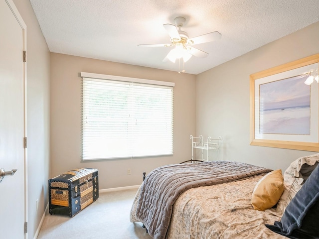 bedroom with ceiling fan, a textured ceiling, baseboards, and carpet