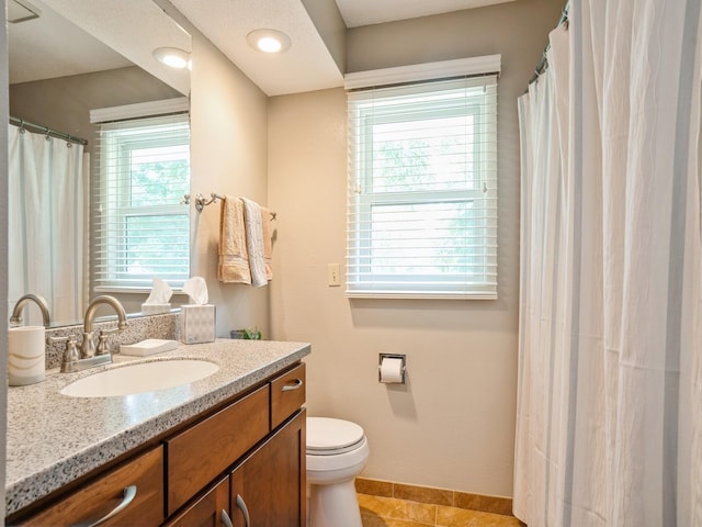 bathroom with tile patterned floors, toilet, vanity, and baseboards