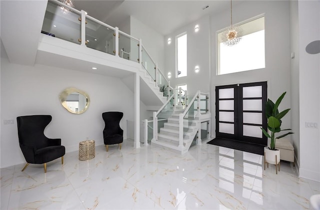 entryway with stairway, visible vents, marble finish floor, and a towering ceiling