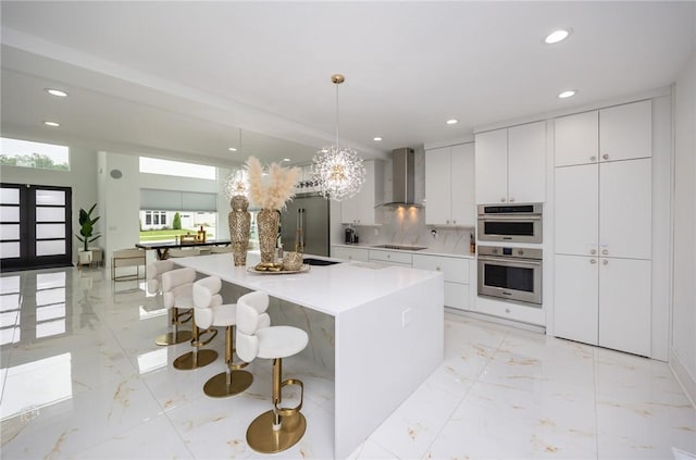 kitchen featuring stainless steel appliances, marble finish floor, recessed lighting, and wall chimney range hood