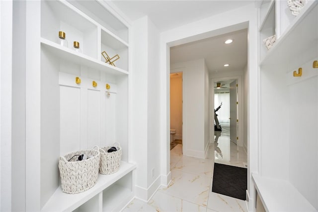 mudroom with recessed lighting, marble finish floor, and baseboards