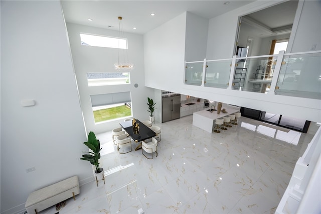 tiled living room featuring a high ceiling and a notable chandelier