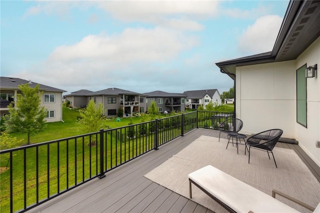 wooden terrace featuring a lawn and a residential view