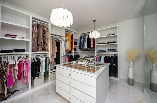 walk in closet featuring marble finish floor and a notable chandelier