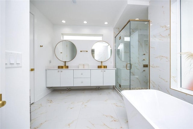 bathroom featuring a freestanding tub, double vanity, a marble finish shower, and recessed lighting