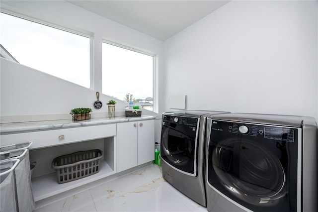 laundry area with light tile patterned flooring and washer and clothes dryer