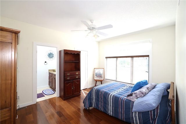 bedroom with ceiling fan, dark wood-type flooring, and connected bathroom