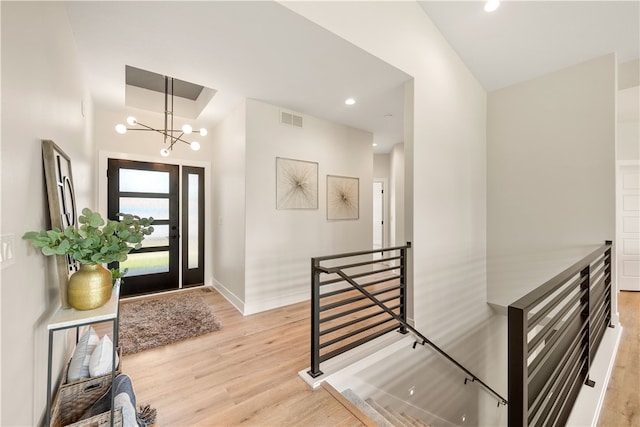 entrance foyer featuring vaulted ceiling, a chandelier, and light hardwood / wood-style floors