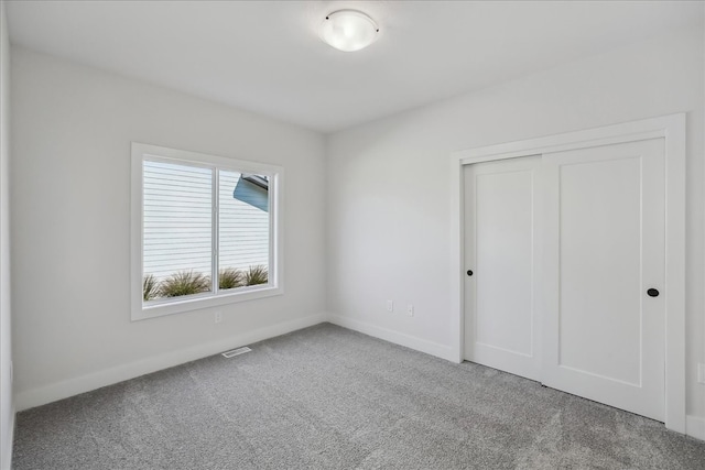 unfurnished bedroom with carpet flooring and a closet