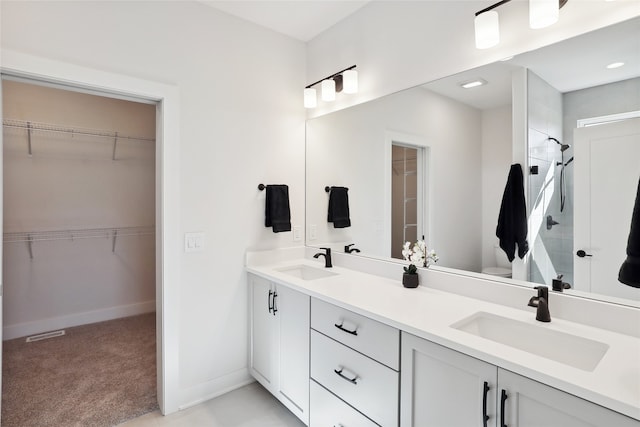 bathroom with tiled shower and vanity