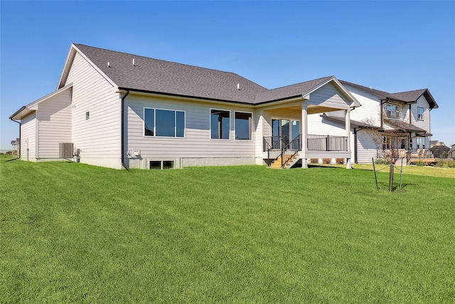 back of property featuring a yard and central AC