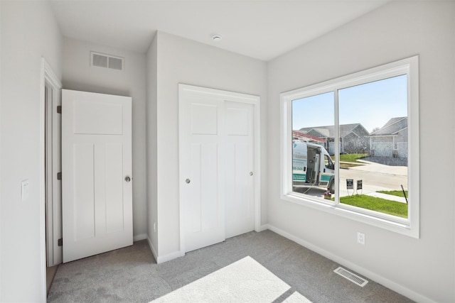 bedroom featuring light colored carpet and a closet