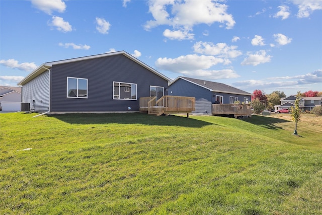 back of property featuring a wooden deck, a yard, and central AC