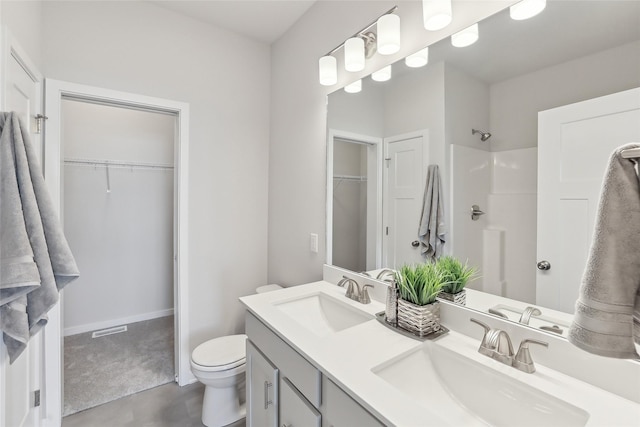 bathroom featuring a shower, vanity, and toilet