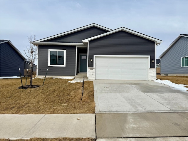 view of front of house with a front yard, concrete driveway, and an attached garage