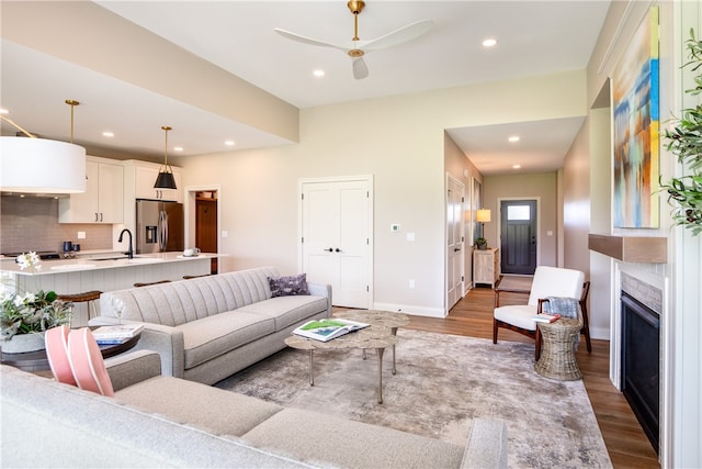 living room with sink, ceiling fan, and hardwood / wood-style floors