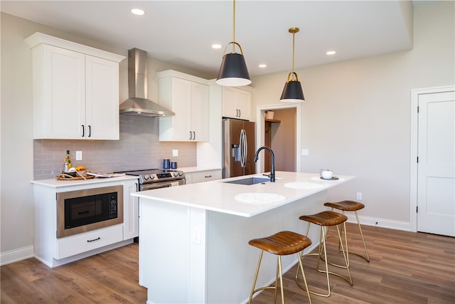 kitchen with sink, stainless steel appliances, light hardwood / wood-style floors, and wall chimney range hood