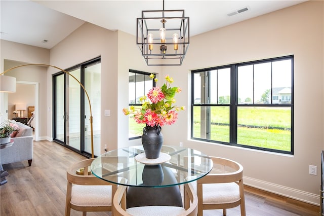 dining room with hardwood / wood-style floors and an inviting chandelier