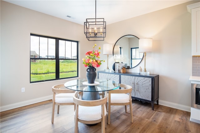 dining space with a notable chandelier and wood-type flooring