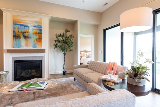 living room with a wealth of natural light, a fireplace, and hardwood / wood-style flooring