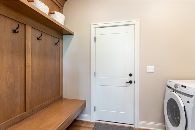 laundry room featuring light hardwood / wood-style floors, washer / clothes dryer, and cabinets