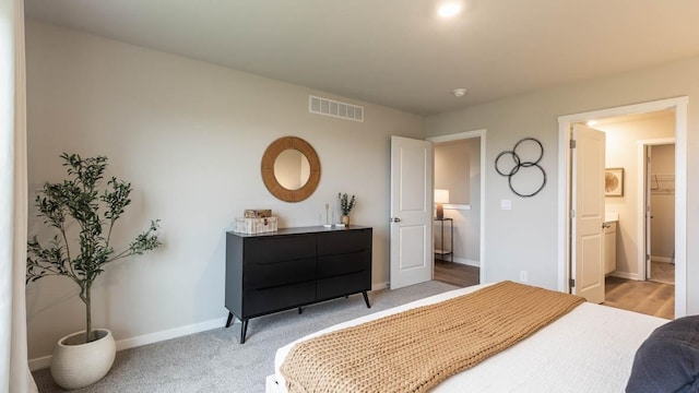 bedroom with light colored carpet, visible vents, and baseboards