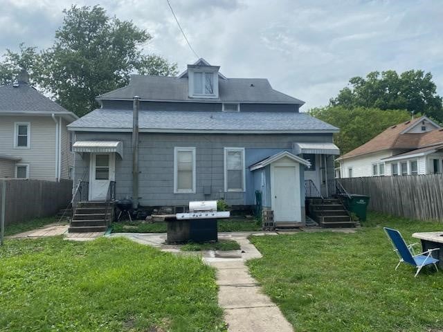 rear view of property featuring a lawn