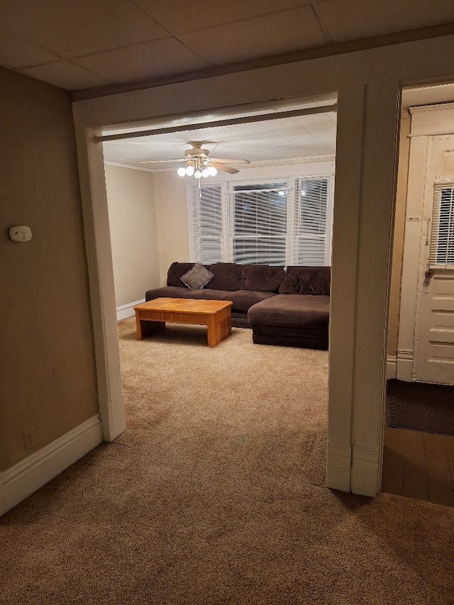 carpeted living room with a drop ceiling and ceiling fan