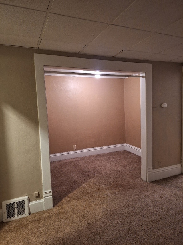 carpeted empty room with a drop ceiling