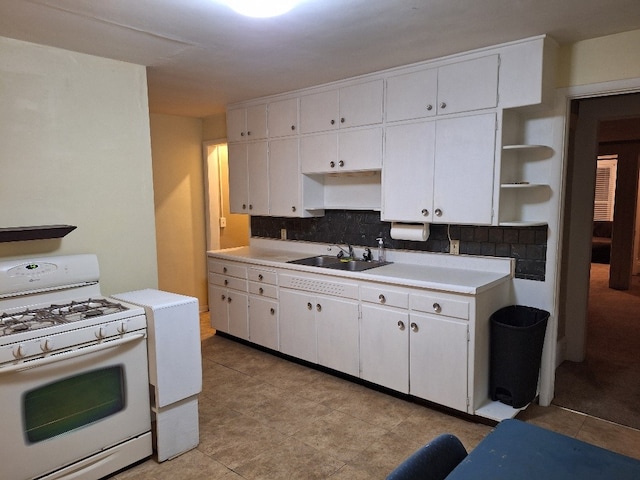 317 7th St, West Des Moines, IA 50265 - kitchen with white range with gas stovetop, a sink, open shelves, tasteful backsplash, and white cabinetry