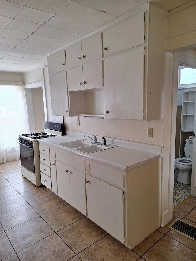 317 7th St, West Des Moines, IA 50265 - kitchen featuring gas range gas stove, a sink, light tile patterned floors, and plenty of natural light