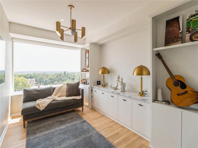 sitting room featuring an inviting chandelier and light hardwood / wood-style flooring