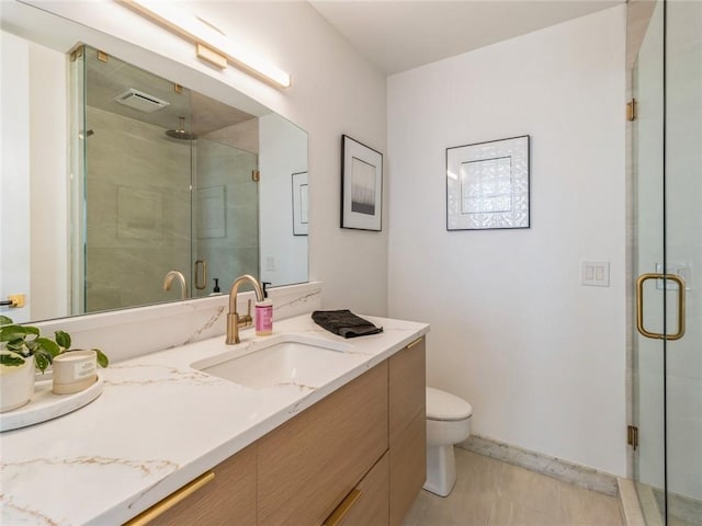 bathroom featuring a shower with door, vanity, and toilet