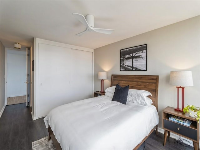 bedroom featuring ceiling fan, dark hardwood / wood-style flooring, and a closet