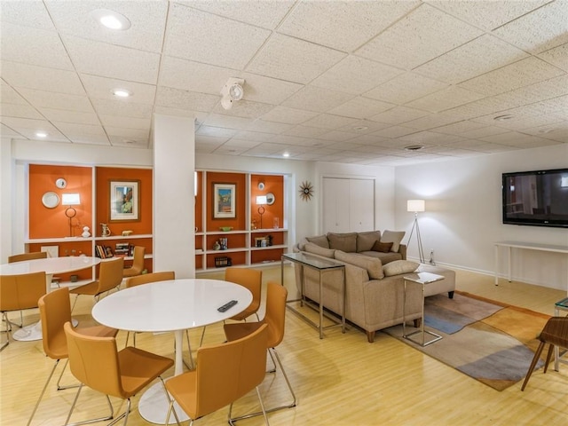 recreation room with light hardwood / wood-style floors and a drop ceiling