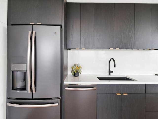 kitchen featuring stainless steel appliances, sink, and gray cabinetry