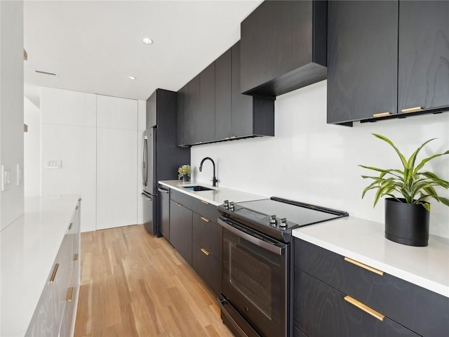 kitchen featuring sink, stainless steel fridge, electric range oven, white cabinets, and light wood-type flooring