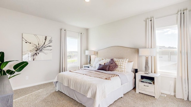 bedroom featuring light carpet and baseboards