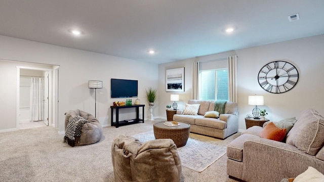 living room with recessed lighting, visible vents, light colored carpet, and baseboards