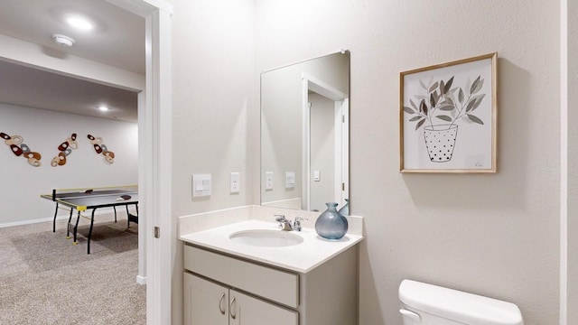 bathroom featuring baseboards, toilet, and vanity