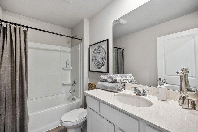 full bathroom with vanity, shower / tub combo, and toilet