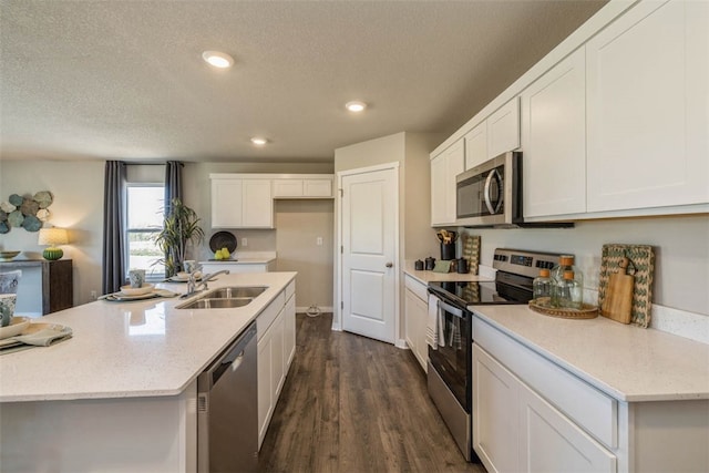 kitchen with dark hardwood / wood-style flooring, a textured ceiling, white cabinetry, sink, and stainless steel appliances