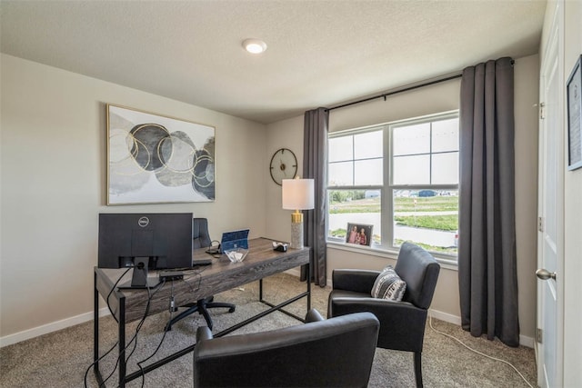 carpeted home office featuring a textured ceiling