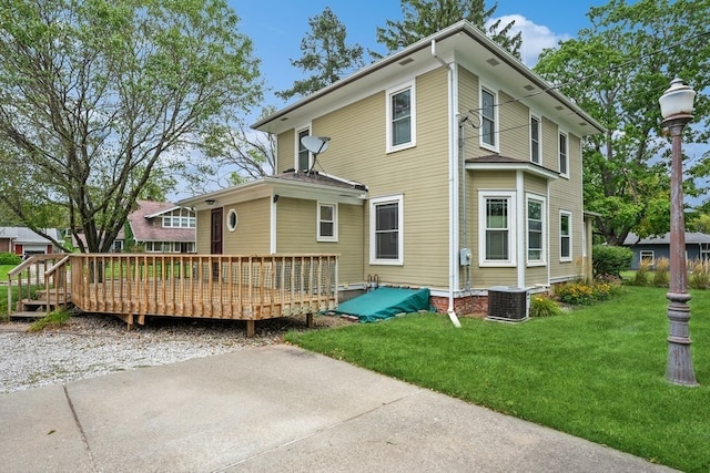 back of property featuring central AC unit, a yard, and a wooden deck