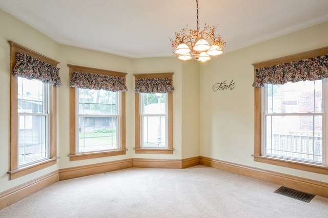 unfurnished dining area featuring carpet and a chandelier