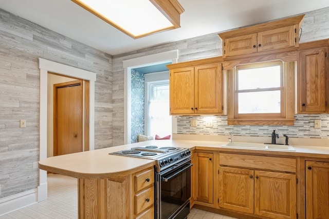 kitchen with black range oven, kitchen peninsula, sink, and a wealth of natural light