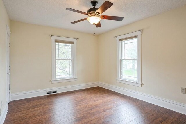 unfurnished room featuring dark hardwood / wood-style floors, ceiling fan, and a textured ceiling